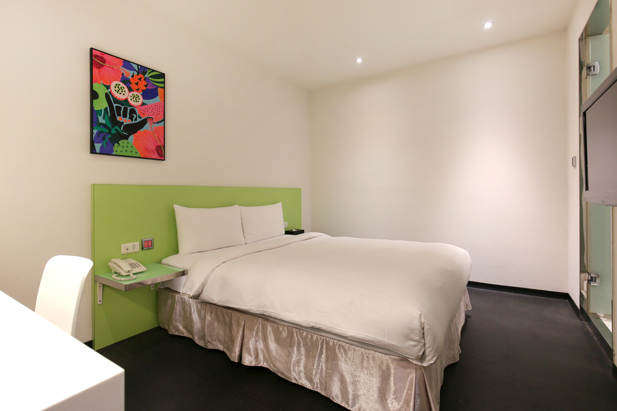 One double bed with a green headboard in the Standard Room at CityInn Hotel Plus Ximending Branch